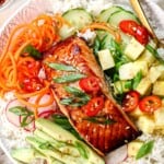 top view of miso glazed salmon being served over rice with vegetables, avocado, and green onions