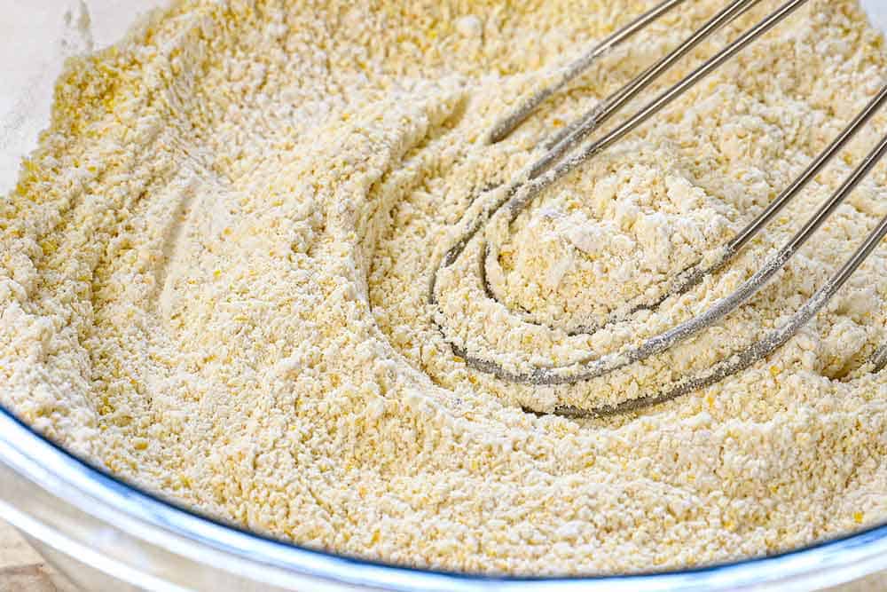 showing how to make skillet cornbread by whisking the Dry ingredients together in a bowl