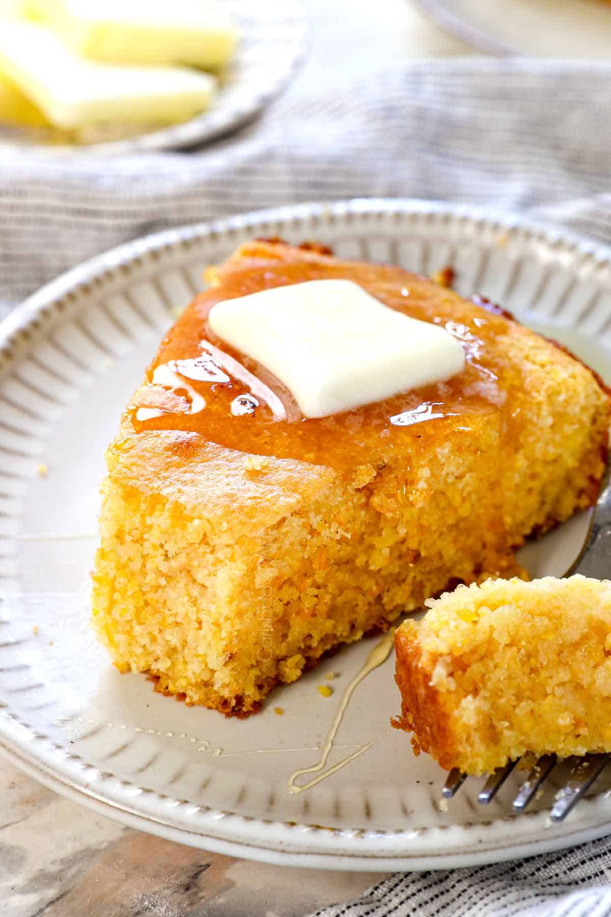 up close of taking a bite out of cast iron skillet cornbread showing how moist it is