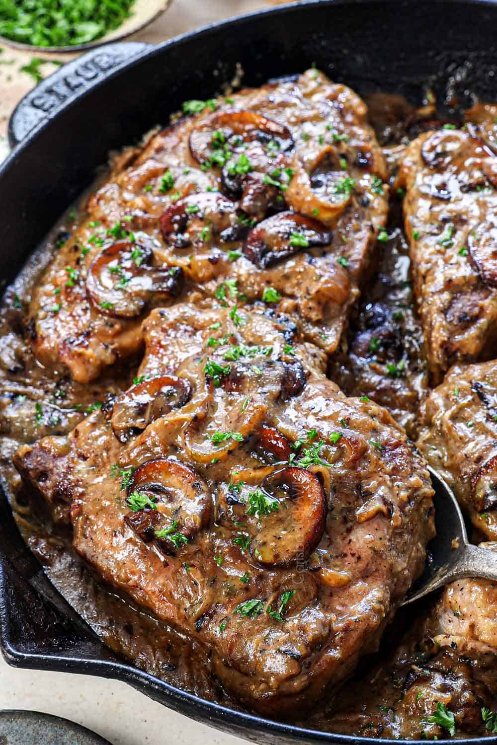 up close of smothered pork chop showing how juicy it is