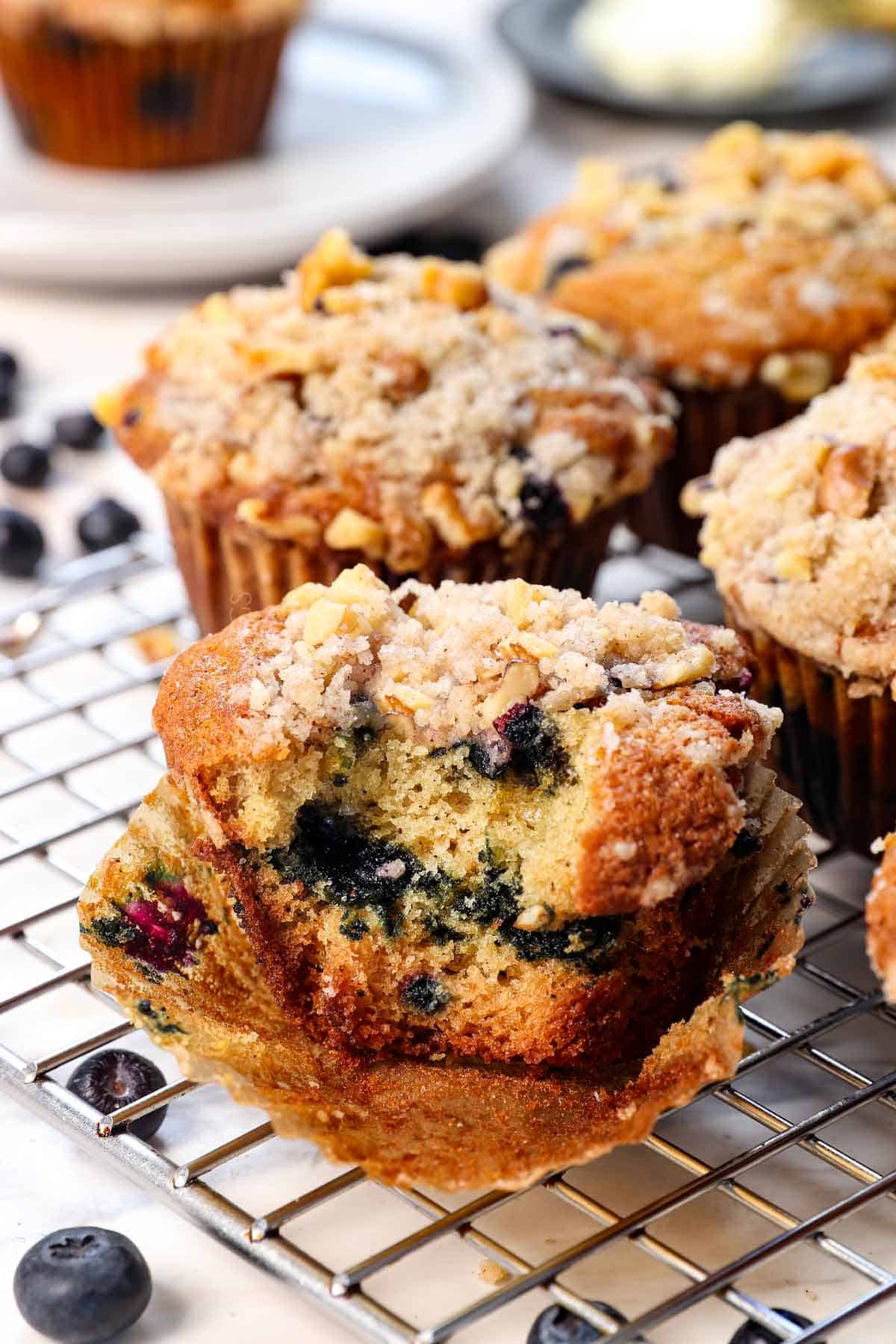 up close of a blueberry muffin with a bite taken out showing the blueberries inside