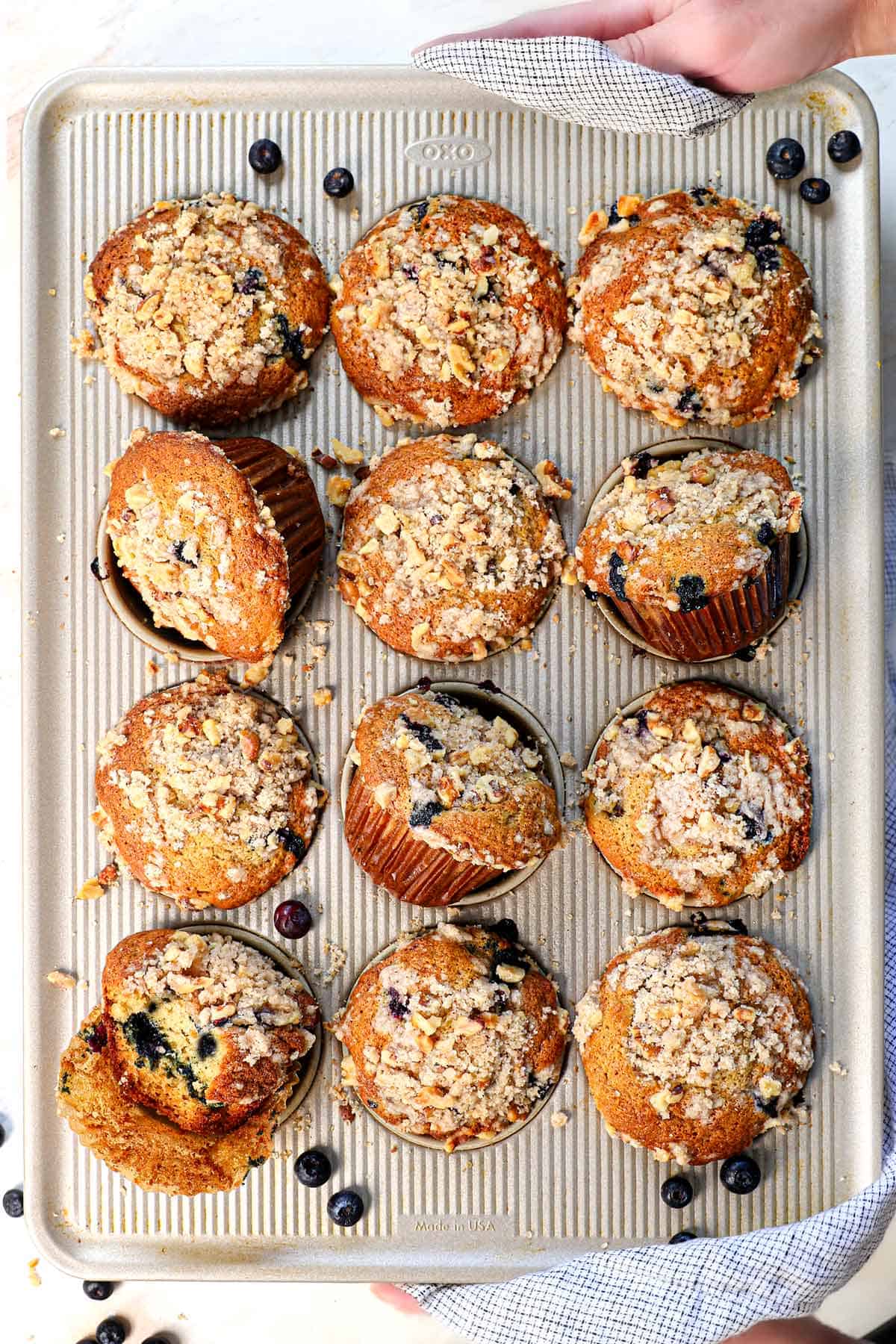 top view of holding a tray of blueberry muffins showing the streusel topping