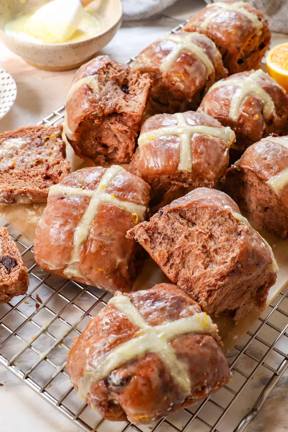 hot cross buns cross on a cooing rack broken apart to show how fluffy they are