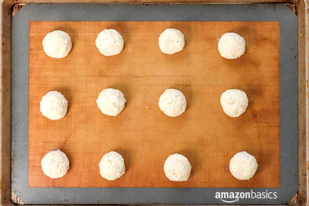 showing how to make lemon cookies recipe by rolling the dough into balls and spacing evenly on a baking sheet