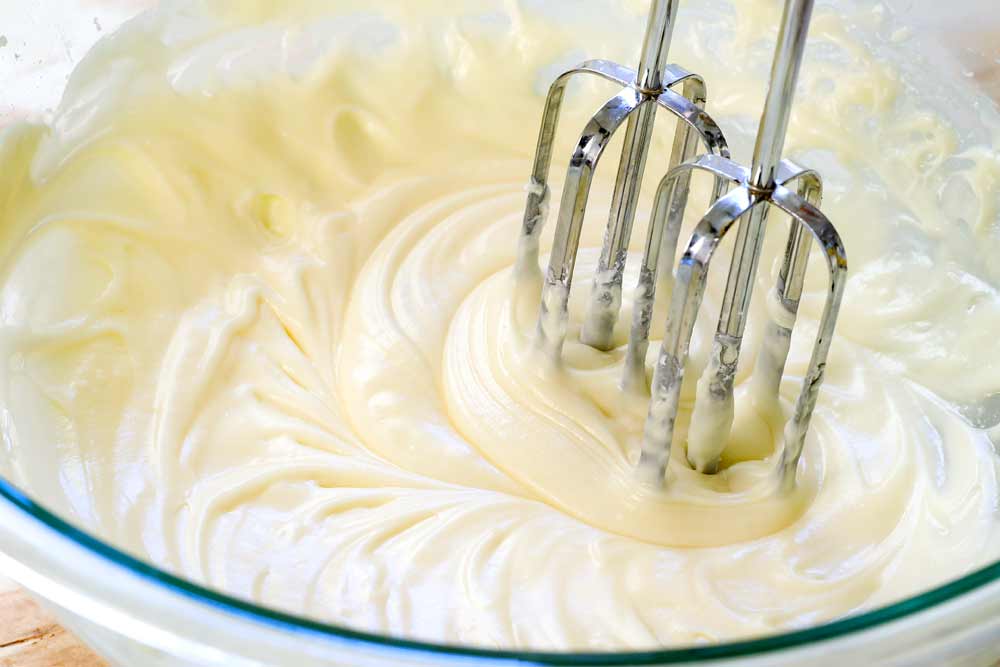 showing how to make lemon cookies by beating the glaze ingredients until smooth