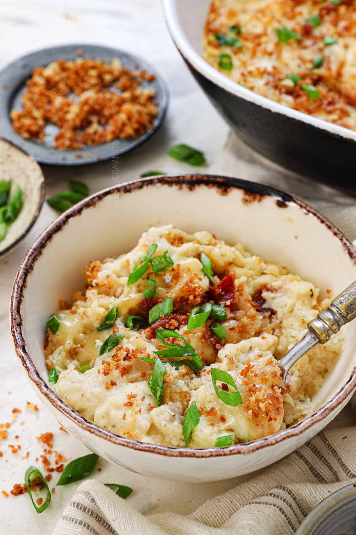 a bowl of loaded mashed potato casserole topped with panko