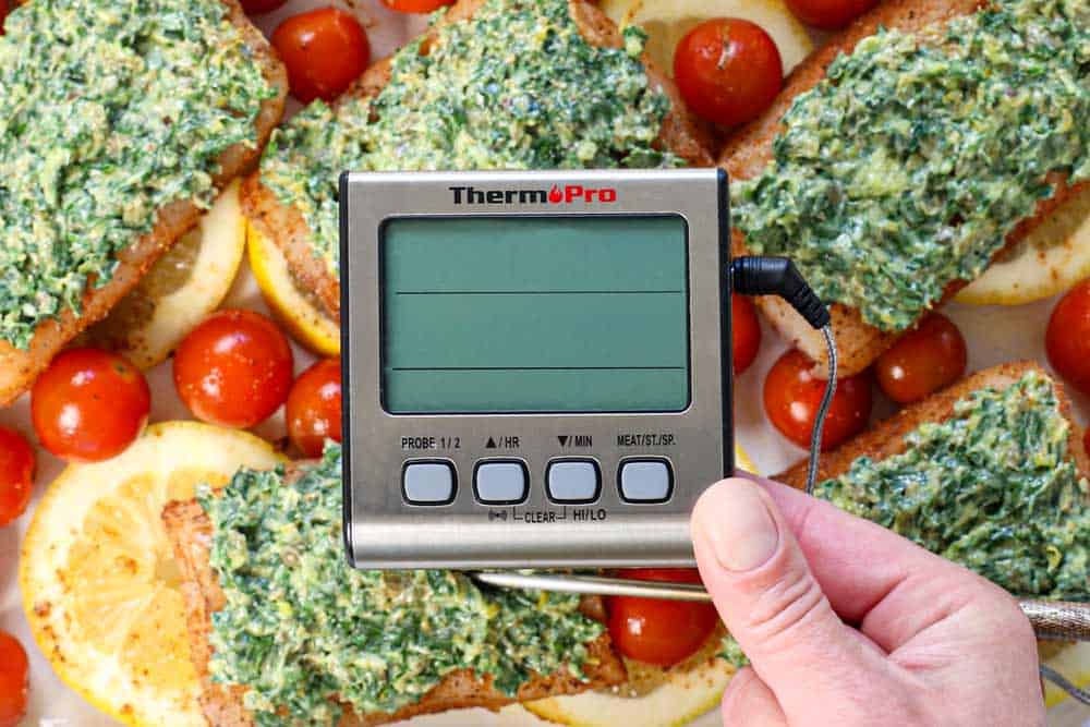 showing how to bake cod by inserting the meat thermometer