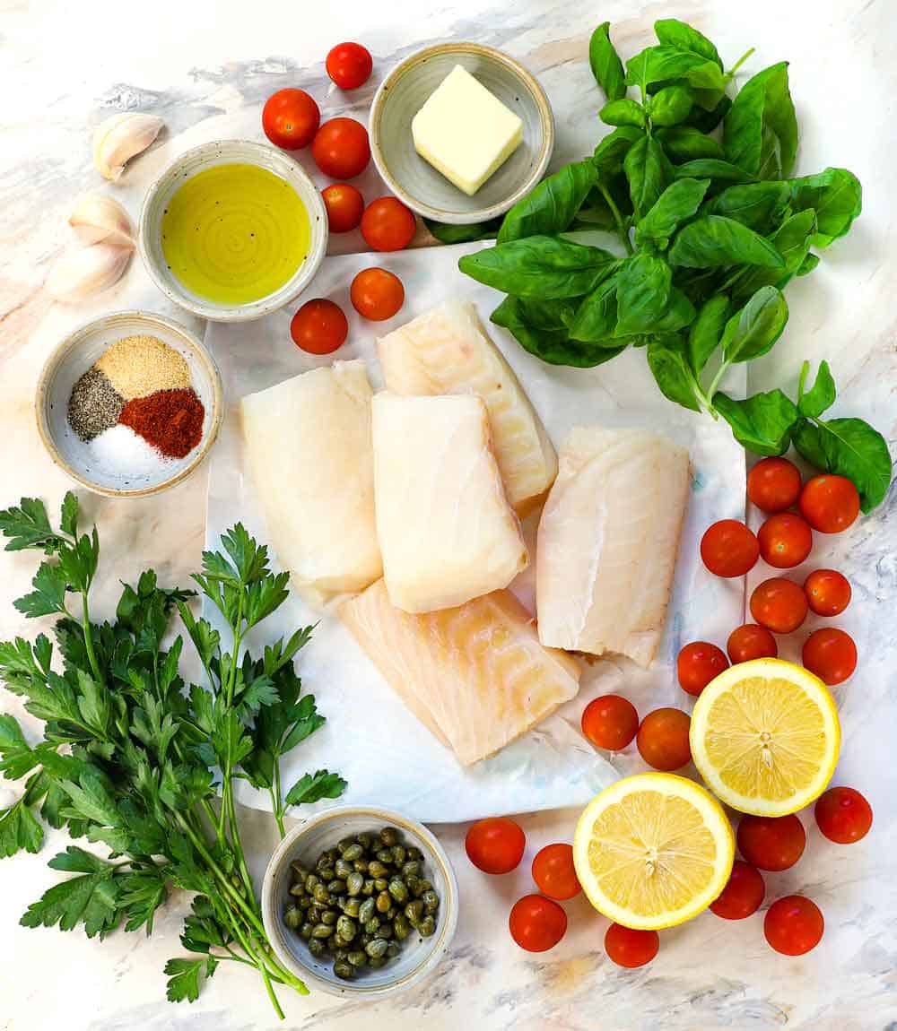 baked cod recipe ingredients: cod fillets, lemon, garlic, olive oil, butter, parsley, basil, capers