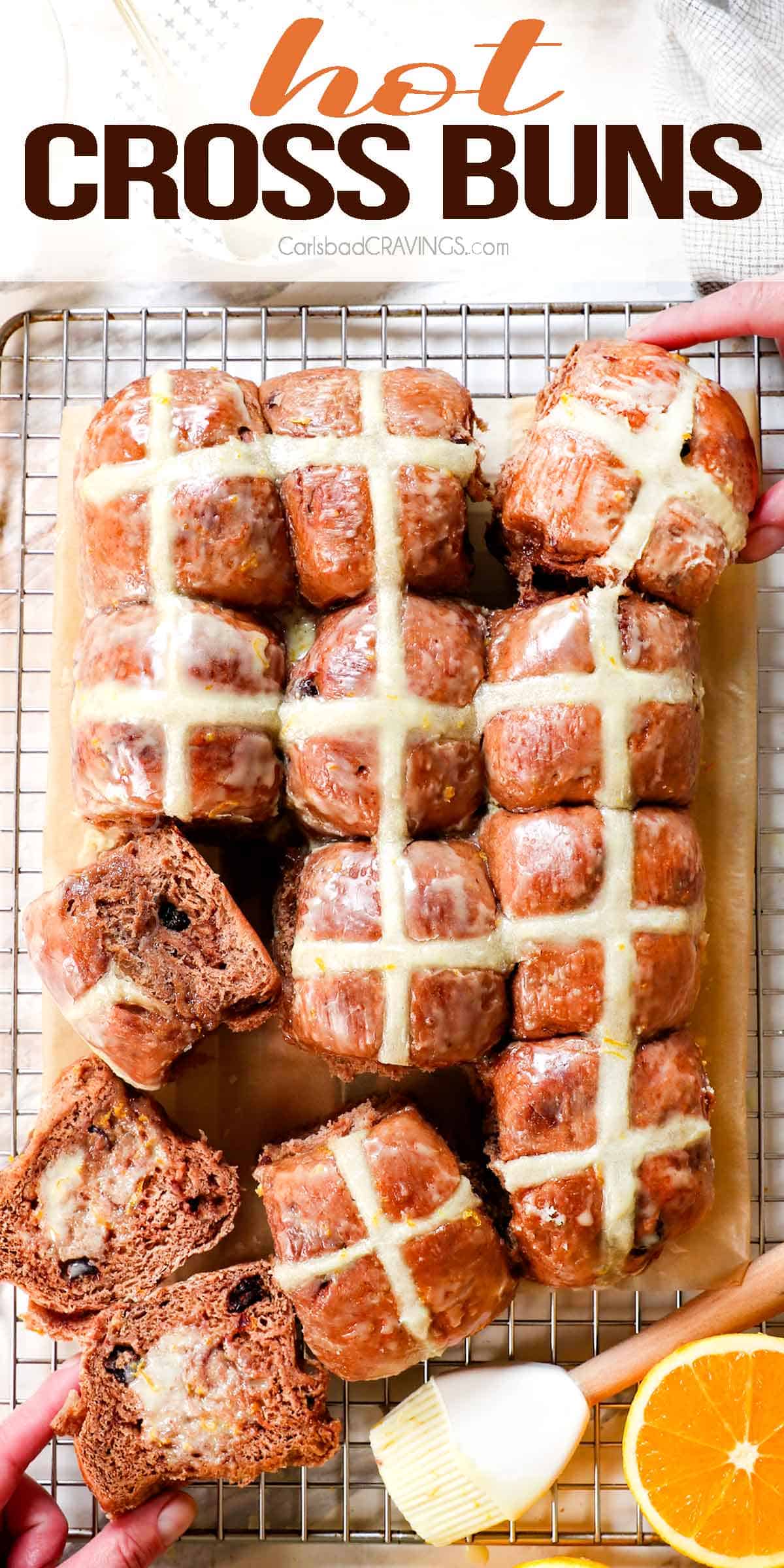 top view of hot cross buns with two hands pulling the rolls apart showing the crosses on the top