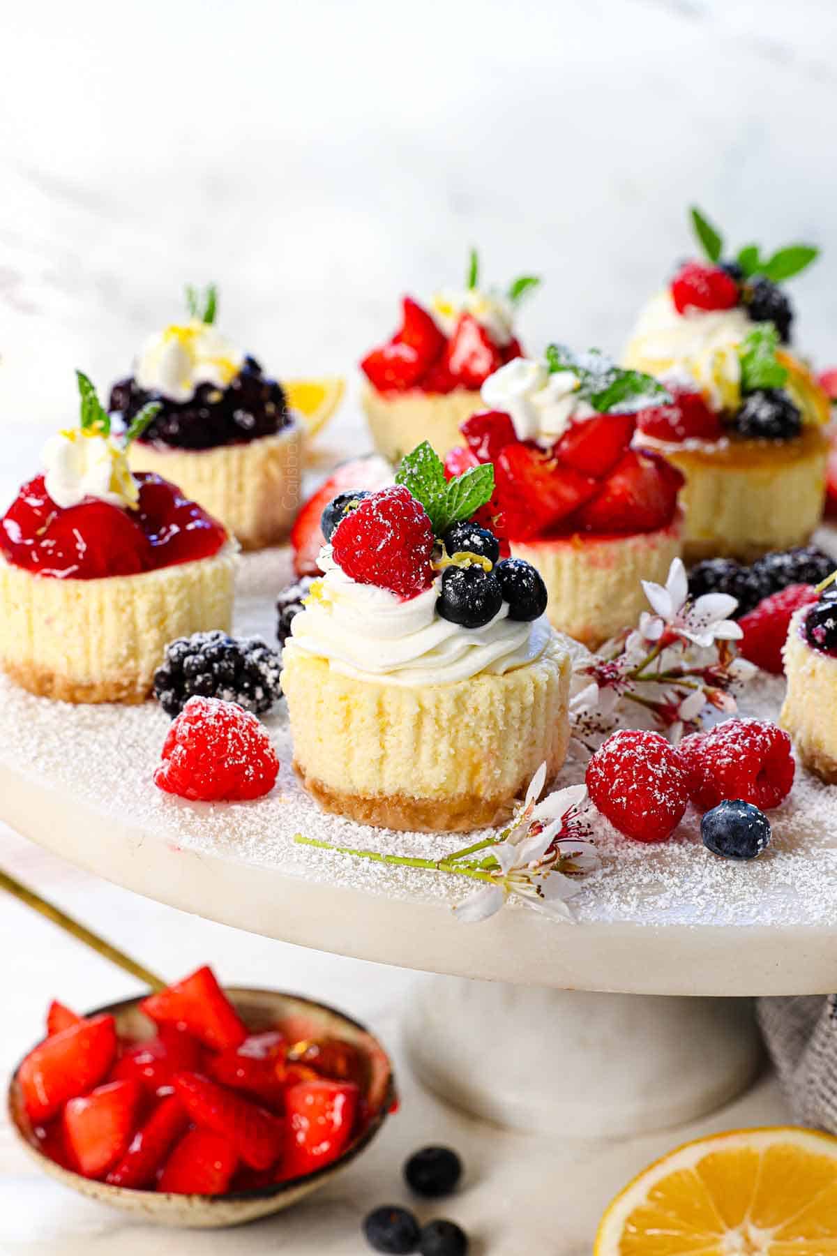 showing how to serve mini cheesecake recipe on a pedestal with various toppings