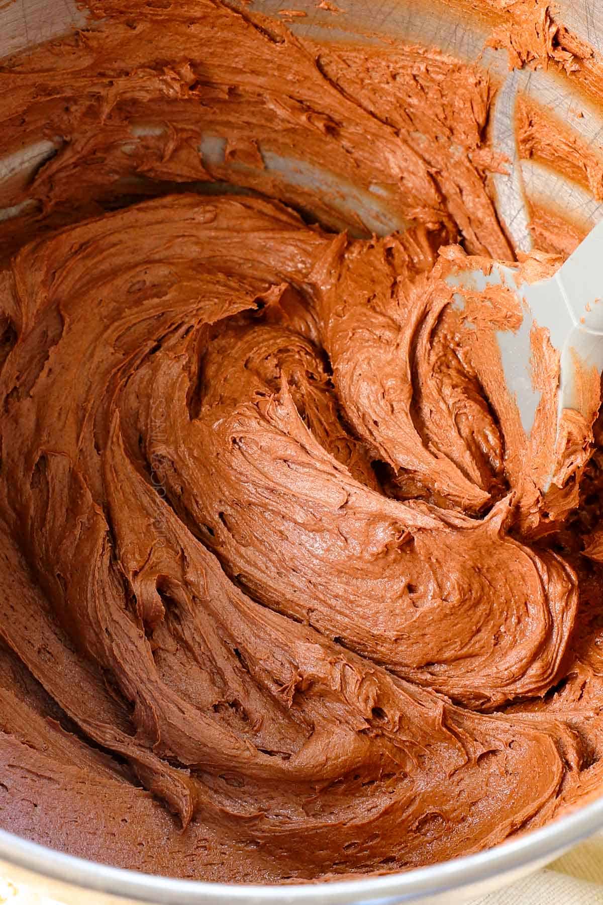 a bowl of chocolate frosting showing how creamy it is